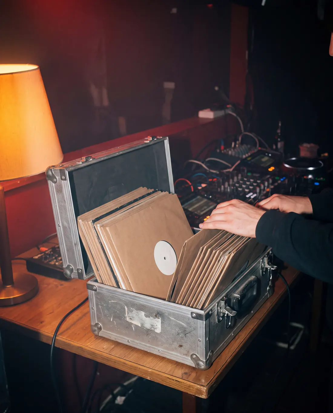 Open platenkoffer met vinyl in een donkere dj-booth